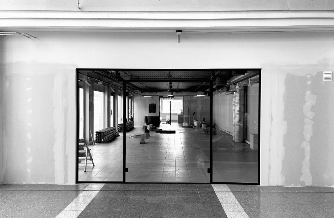 Interior view of GalleryLab entrance with glass walls, black and white