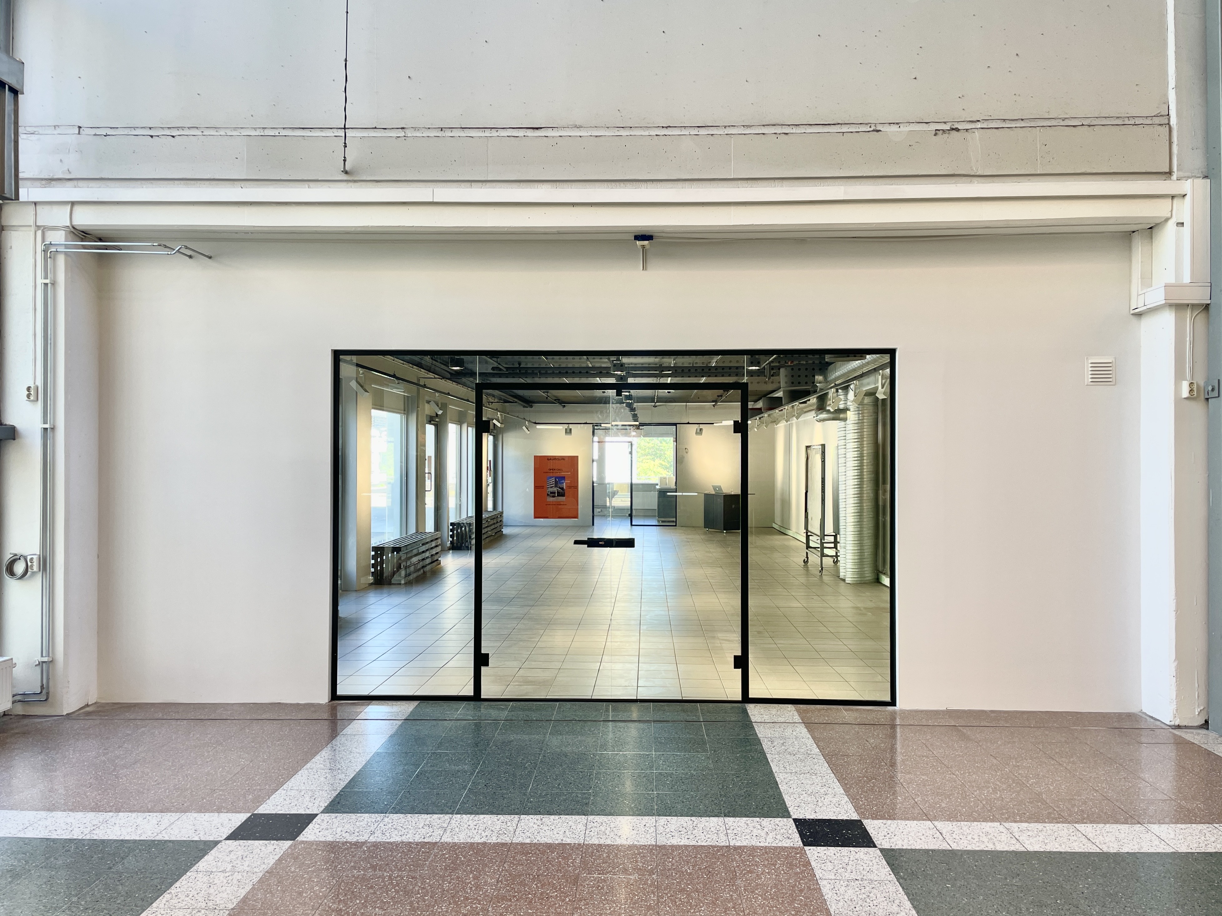 Exterior view of GalleryLab entrance showing the modern gallery space through large glass doors