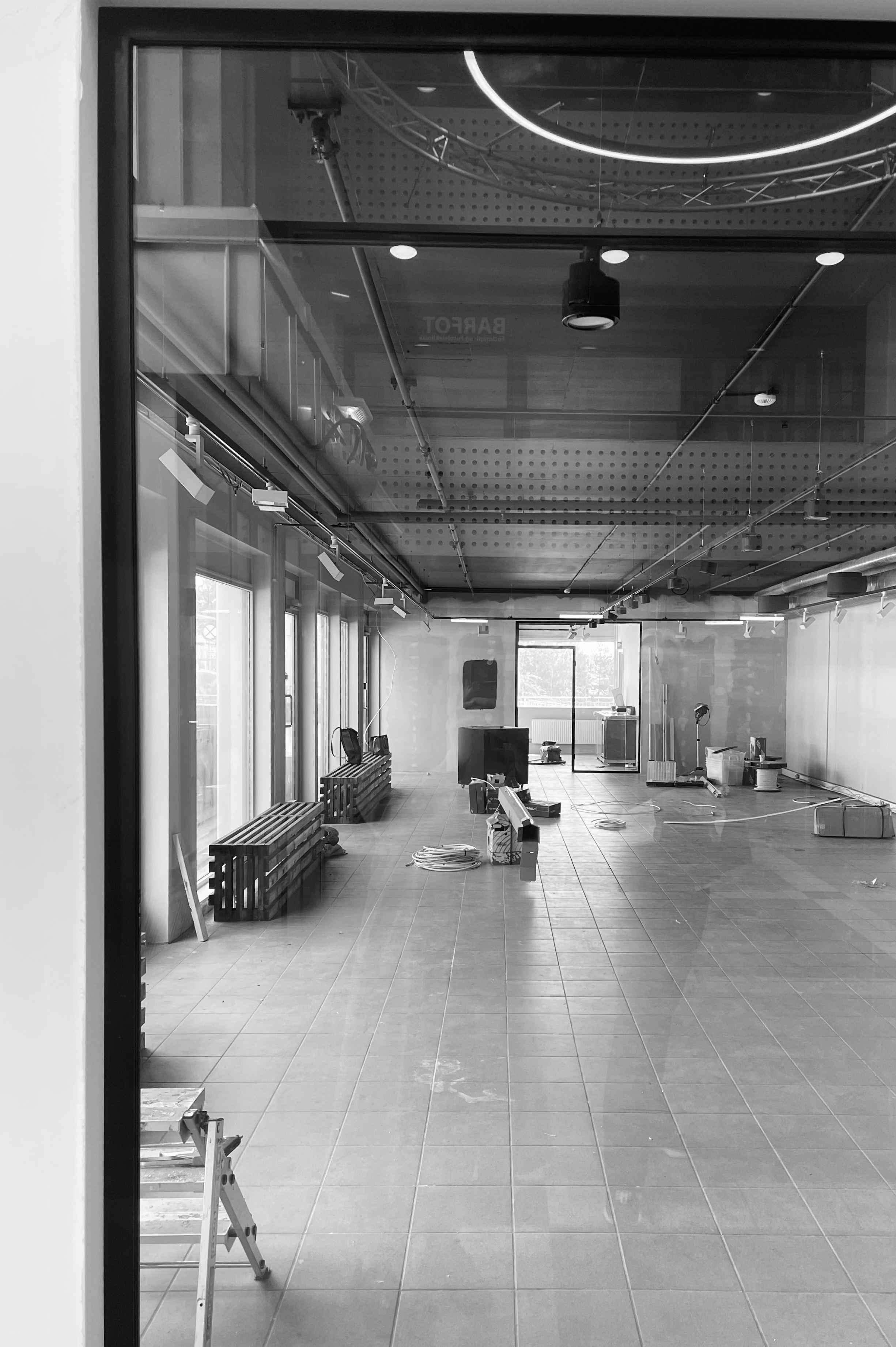 Interior view of gallery space with track lighting and large windows